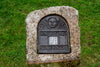 Stone monument with a plaque featuring 'Rhode Island Slave History' on a grassy background